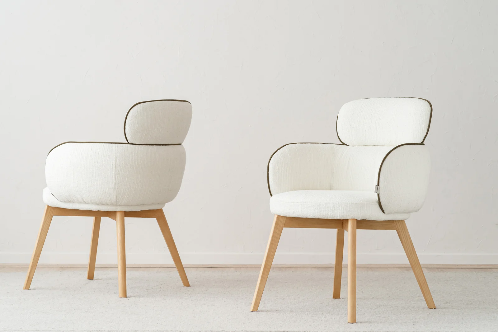 Sillas de diseño contemporáneo con tapizado bouclé blanco y patas de madera natural para proyectos contract